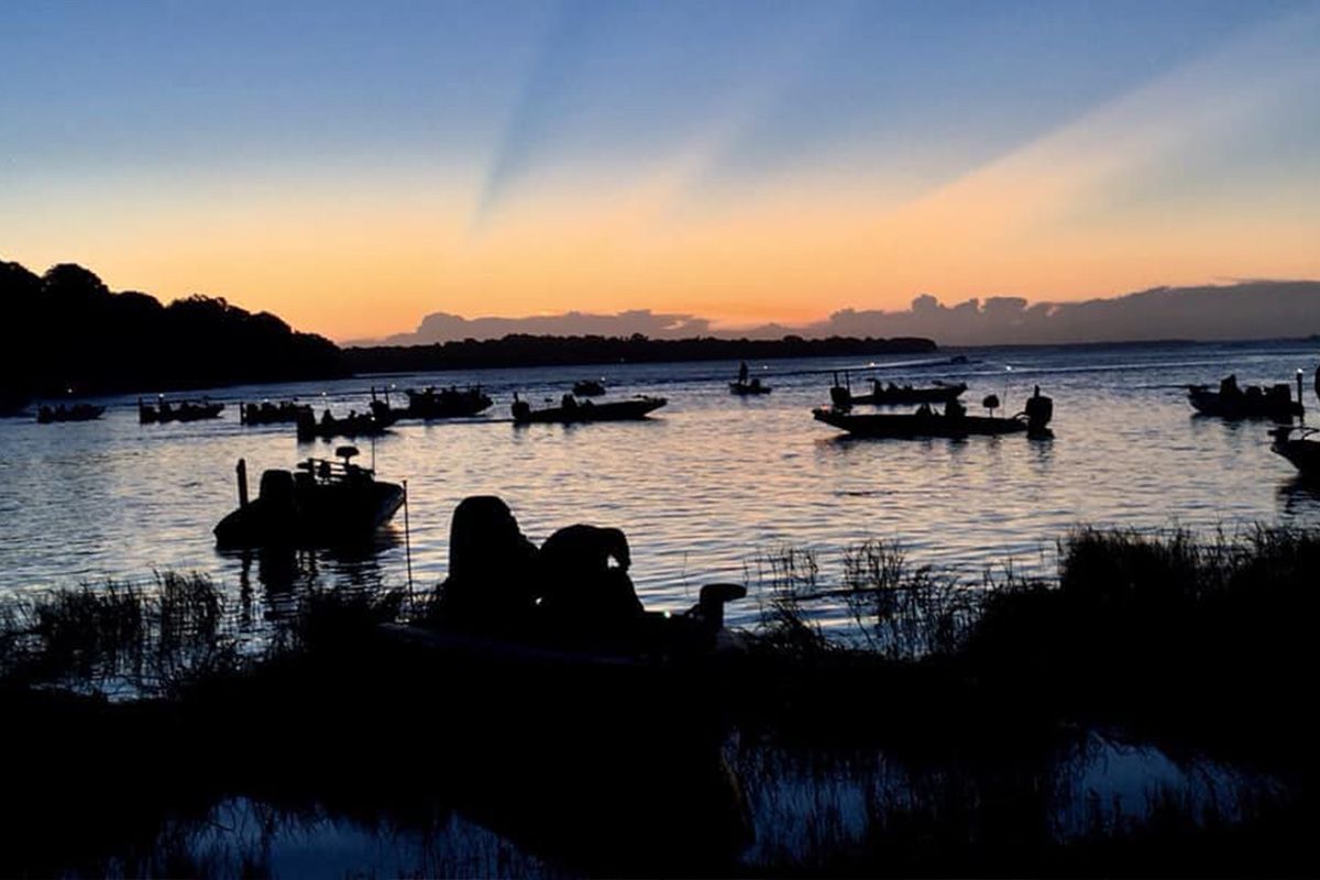 Fishing boats gathering on a lake at sunrise