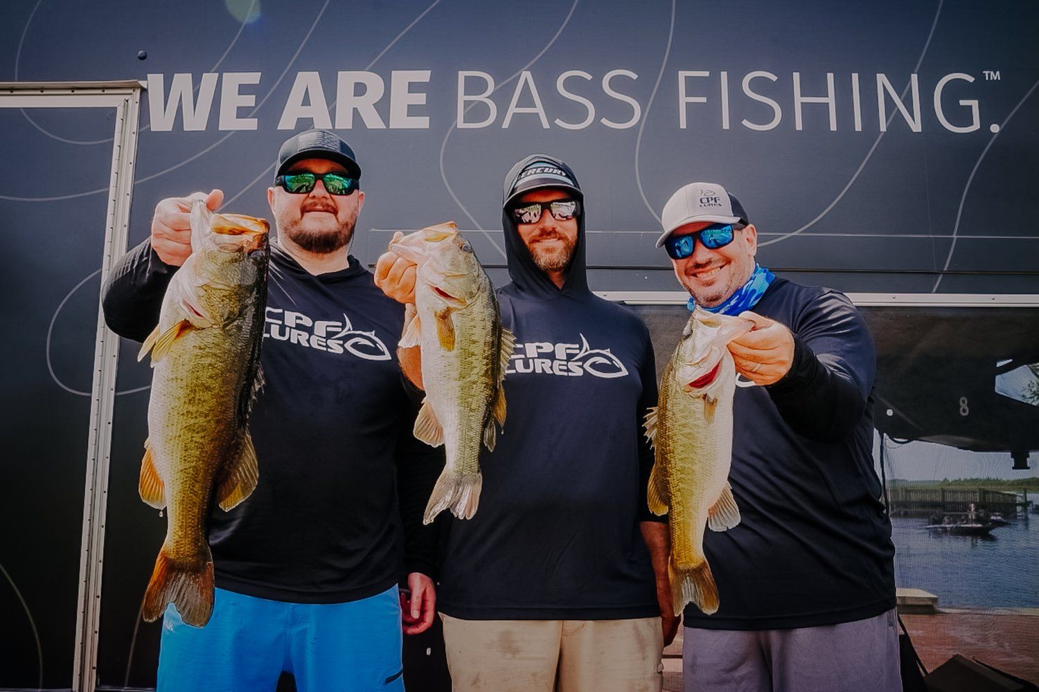 Three anglers holding bass together during the 2023 iCast Cup