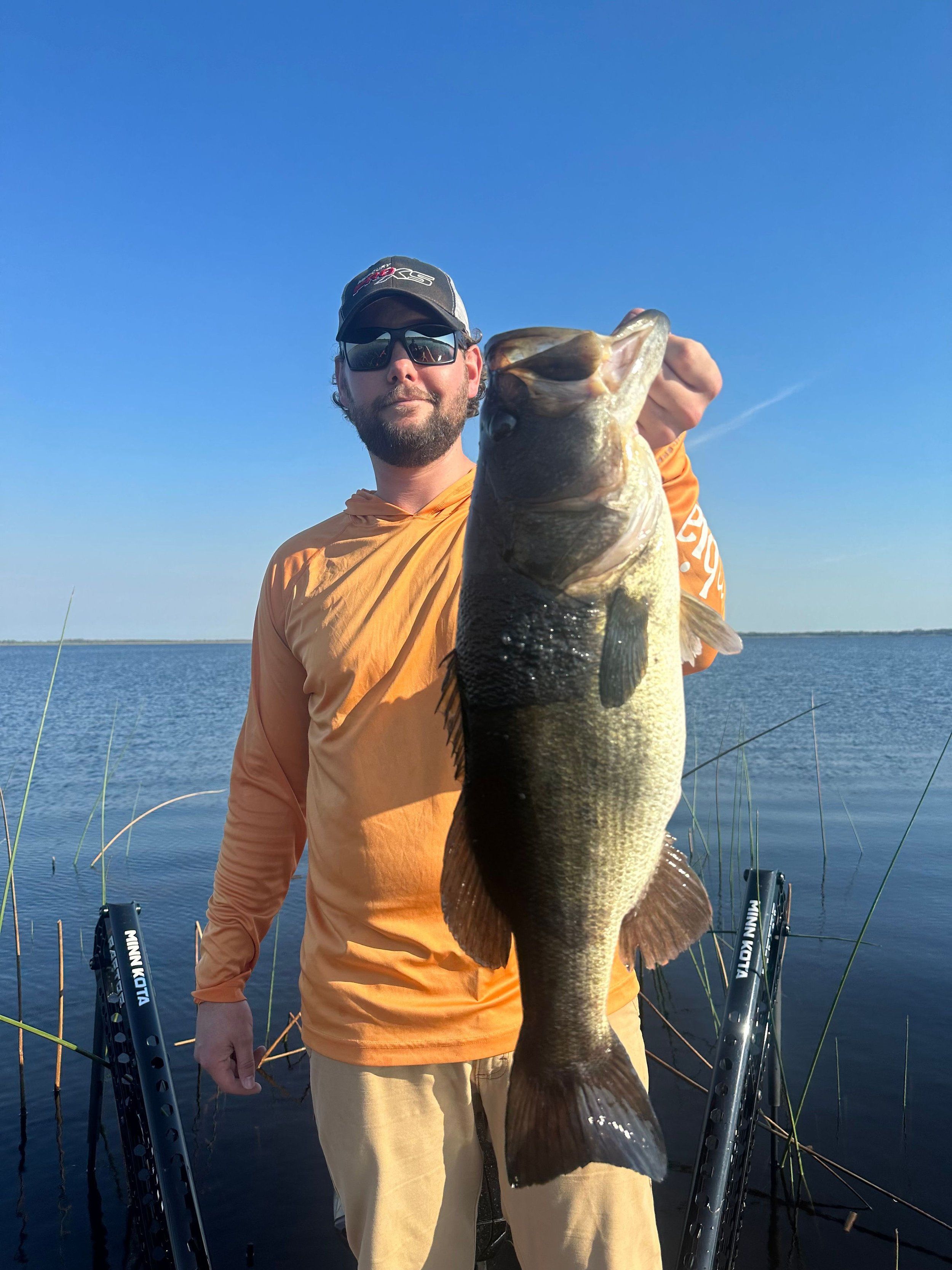 Angler holding a largemouth bass during a guided fishing trip