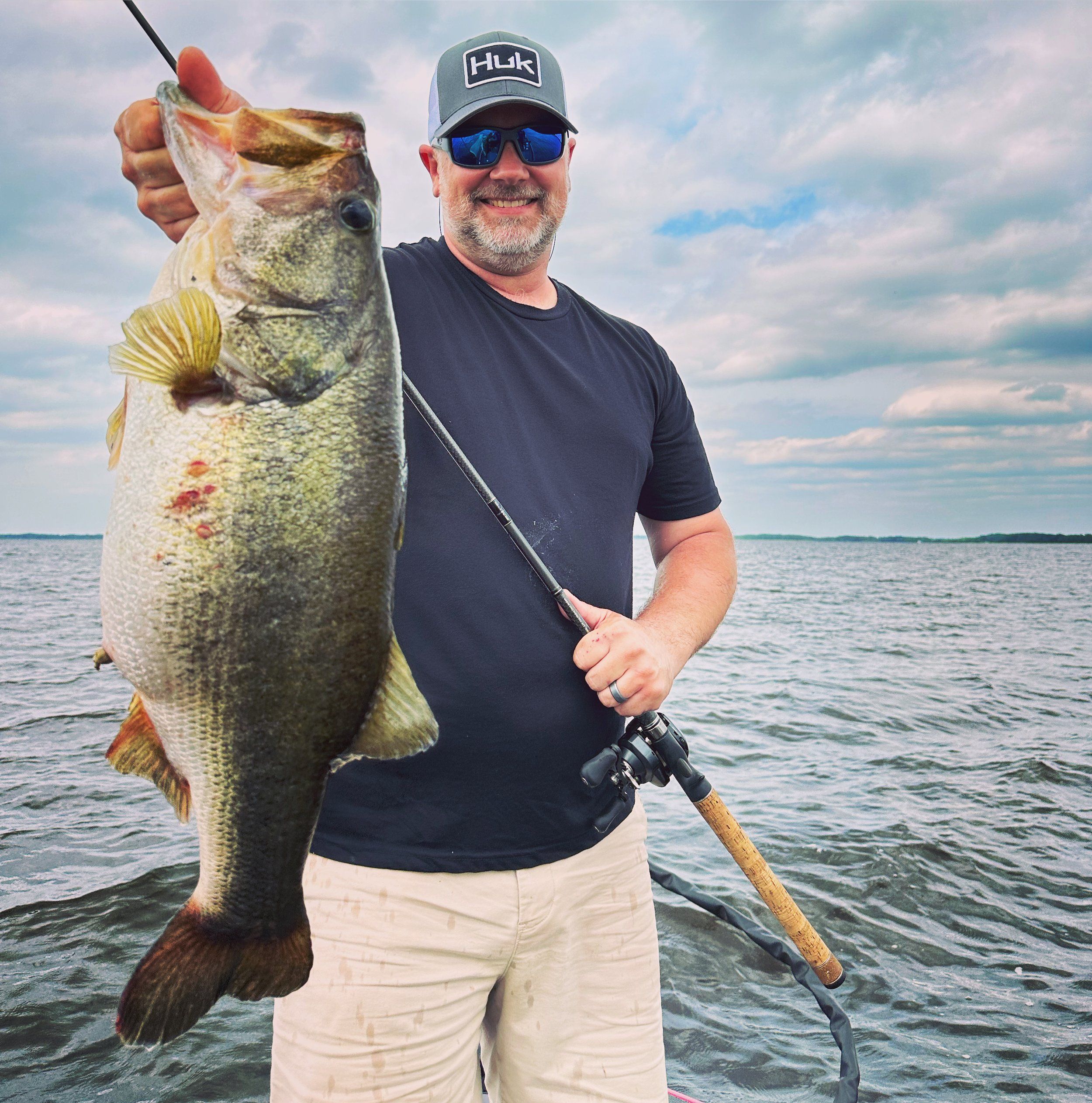 Angler holding a trophy largemouth bass during a guided fishing trip